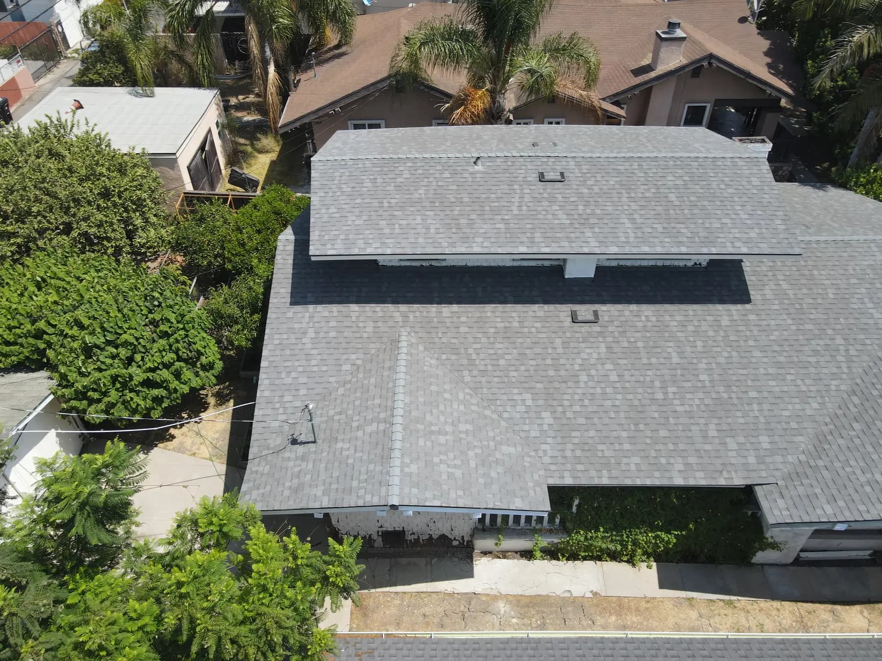 Rear view of the home with its new shingle roof, straight ridges and box vents