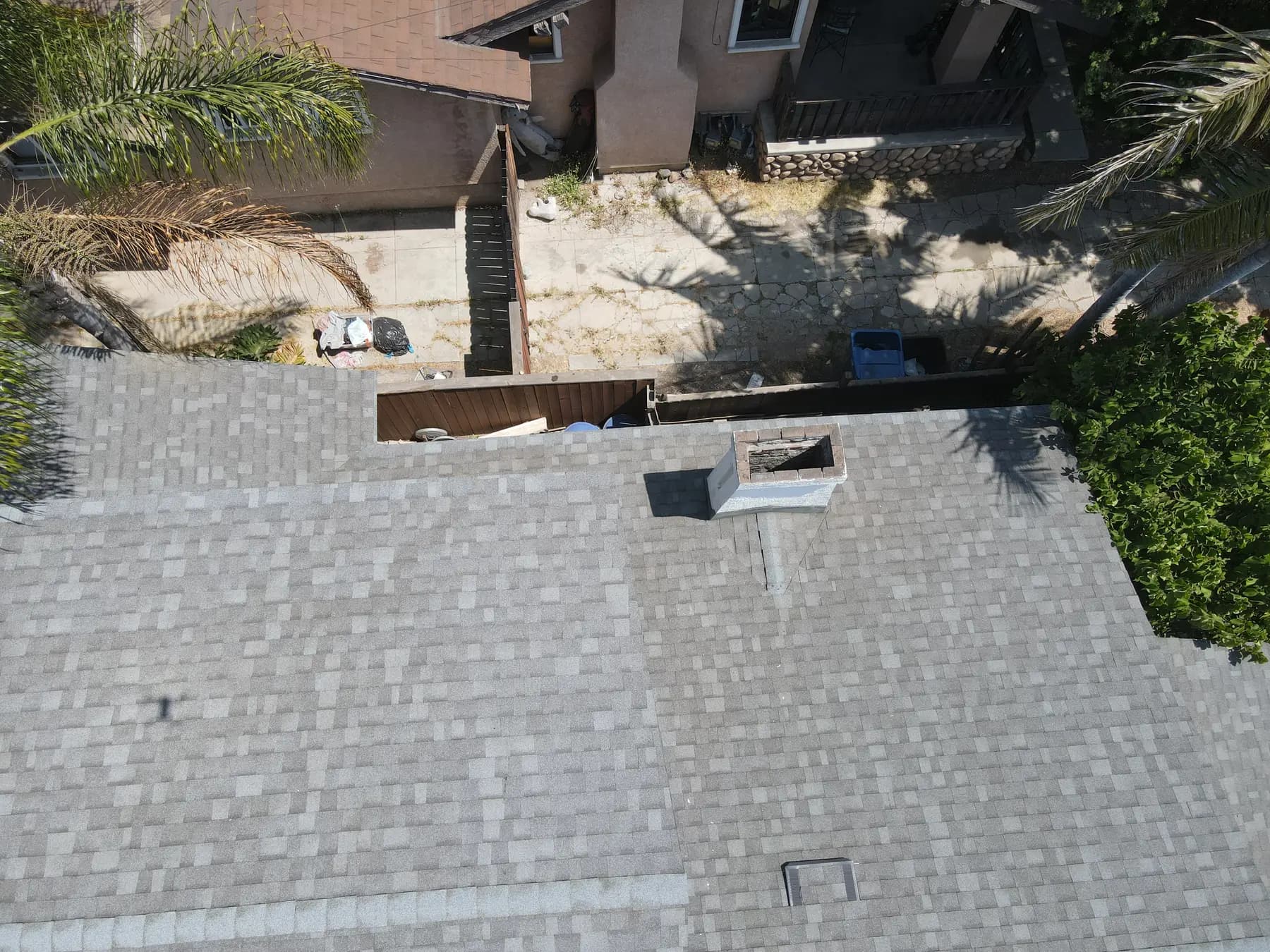The new shingle roof beside the chimney, with its metal cap and flashing, and a box vent