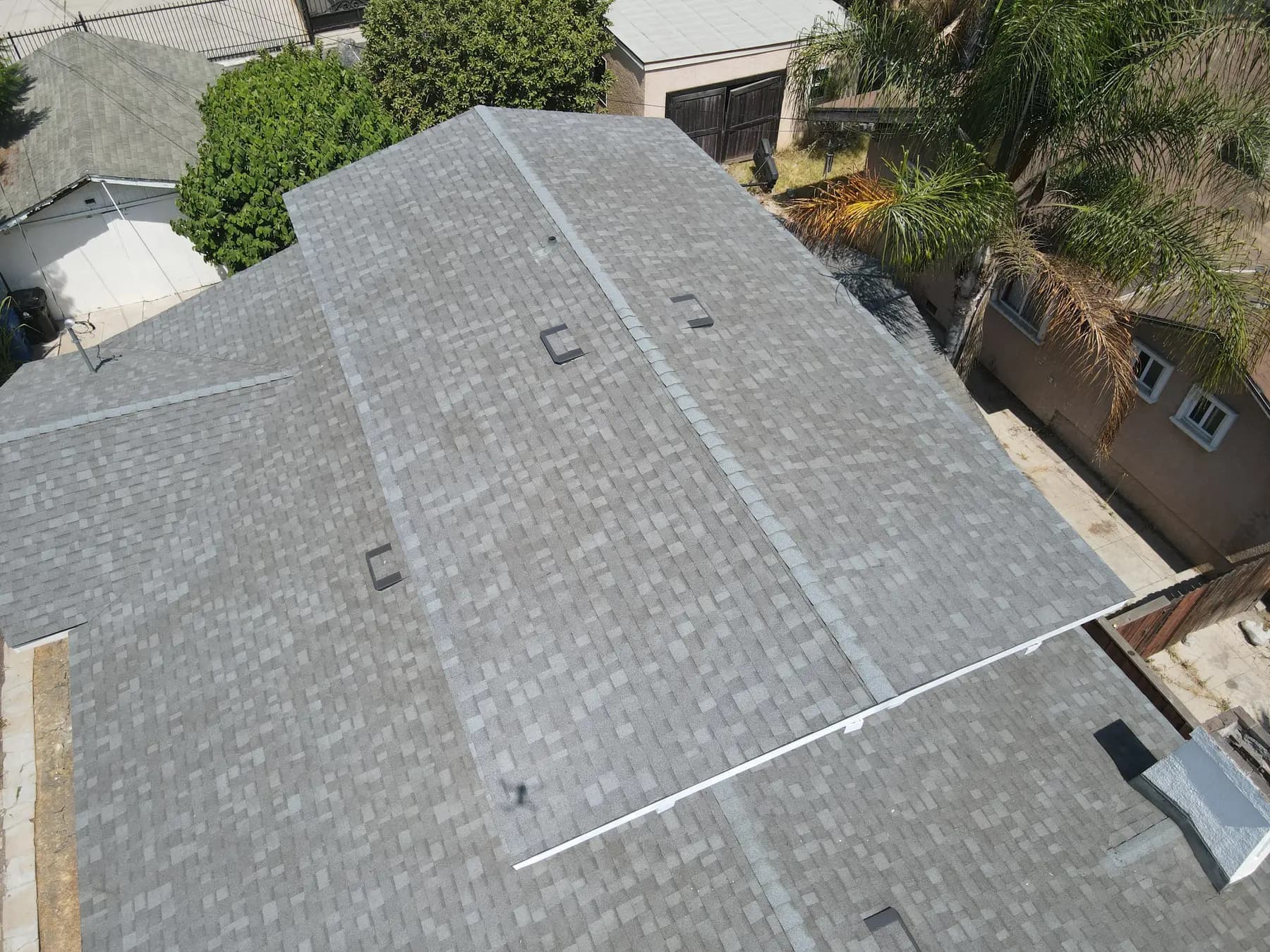 Overhead view of a hip and ridge, with the new shingles, box vents and a metal vent cap