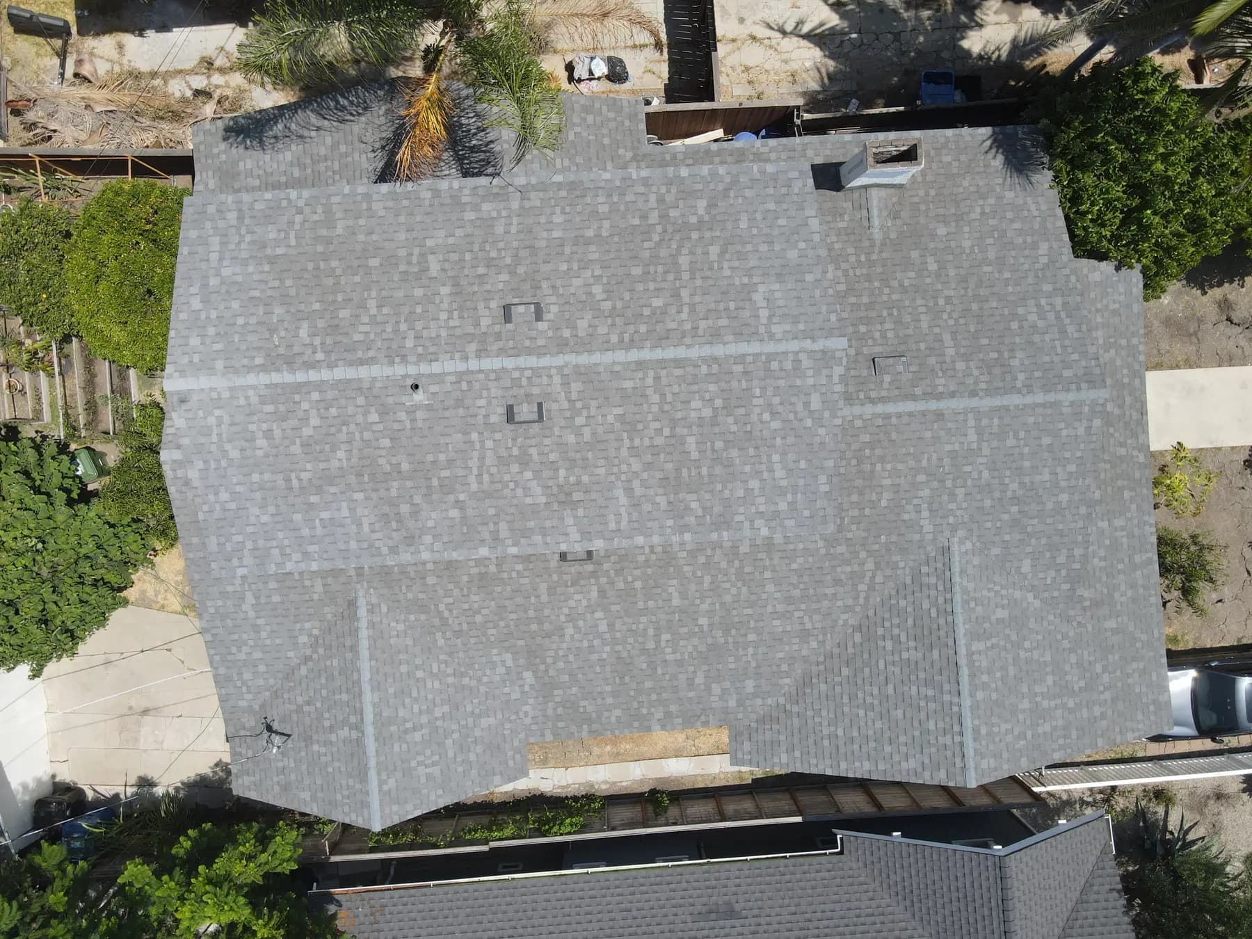 Straight-down view of the whole roof, with its box vents, chimney and clean ridge lines