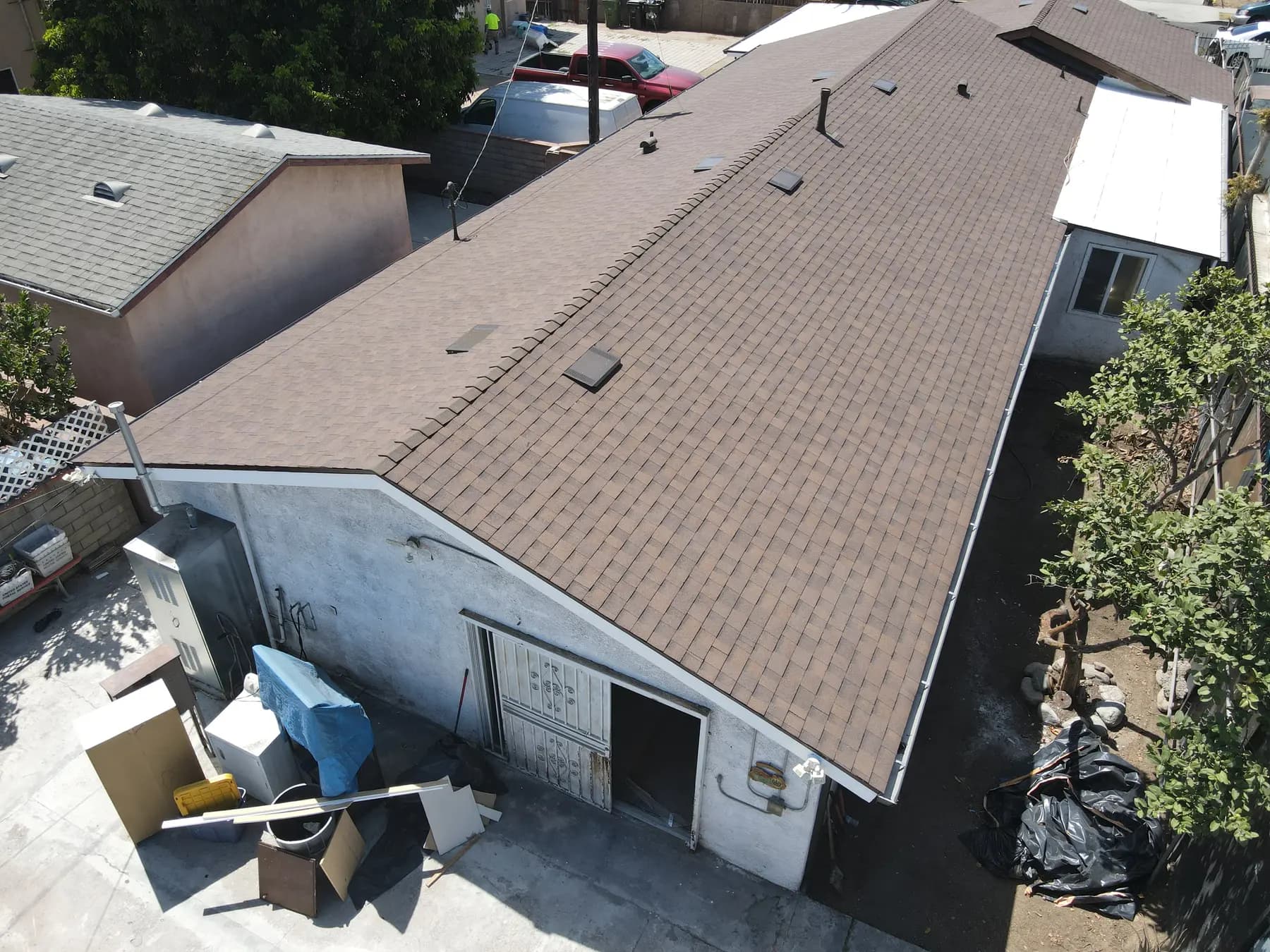 The rear building seen from the corner, with the new shingle roof running straight from ridge to eave
