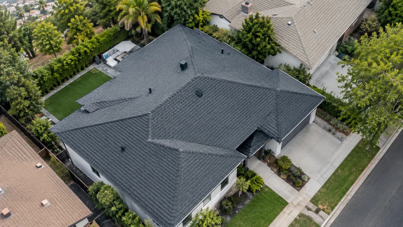 Aerial view of a shingle roof on a home with palm trees