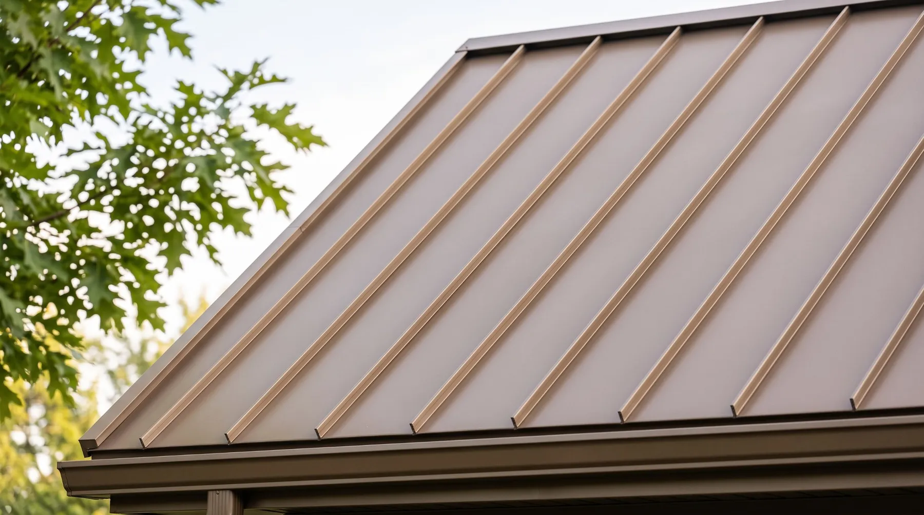 Close-up of bronze standing seam metal roof panels with raised seams running down to the eave