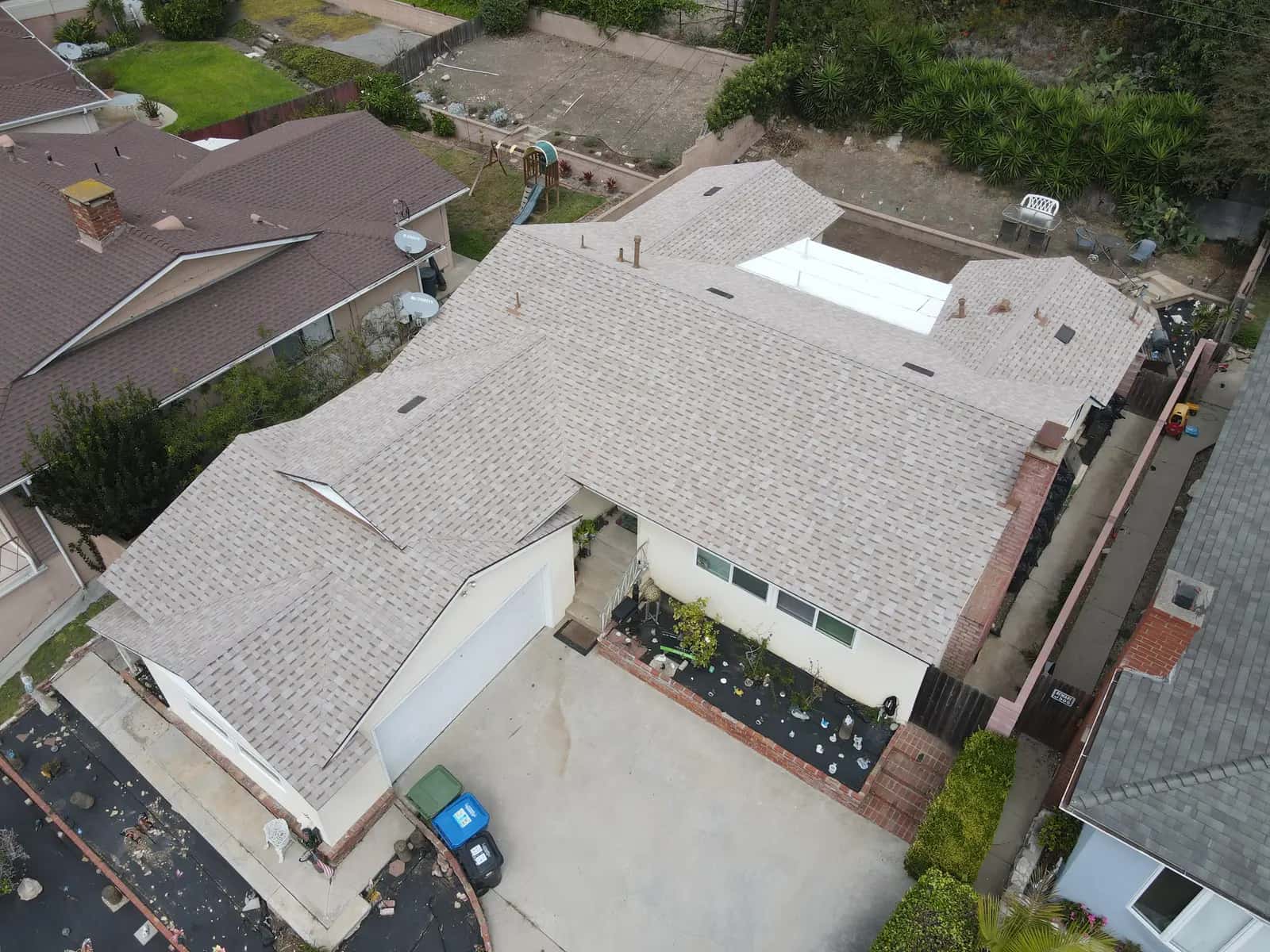 Aerial view of the new shingle roof over the home and its two-car garage wing