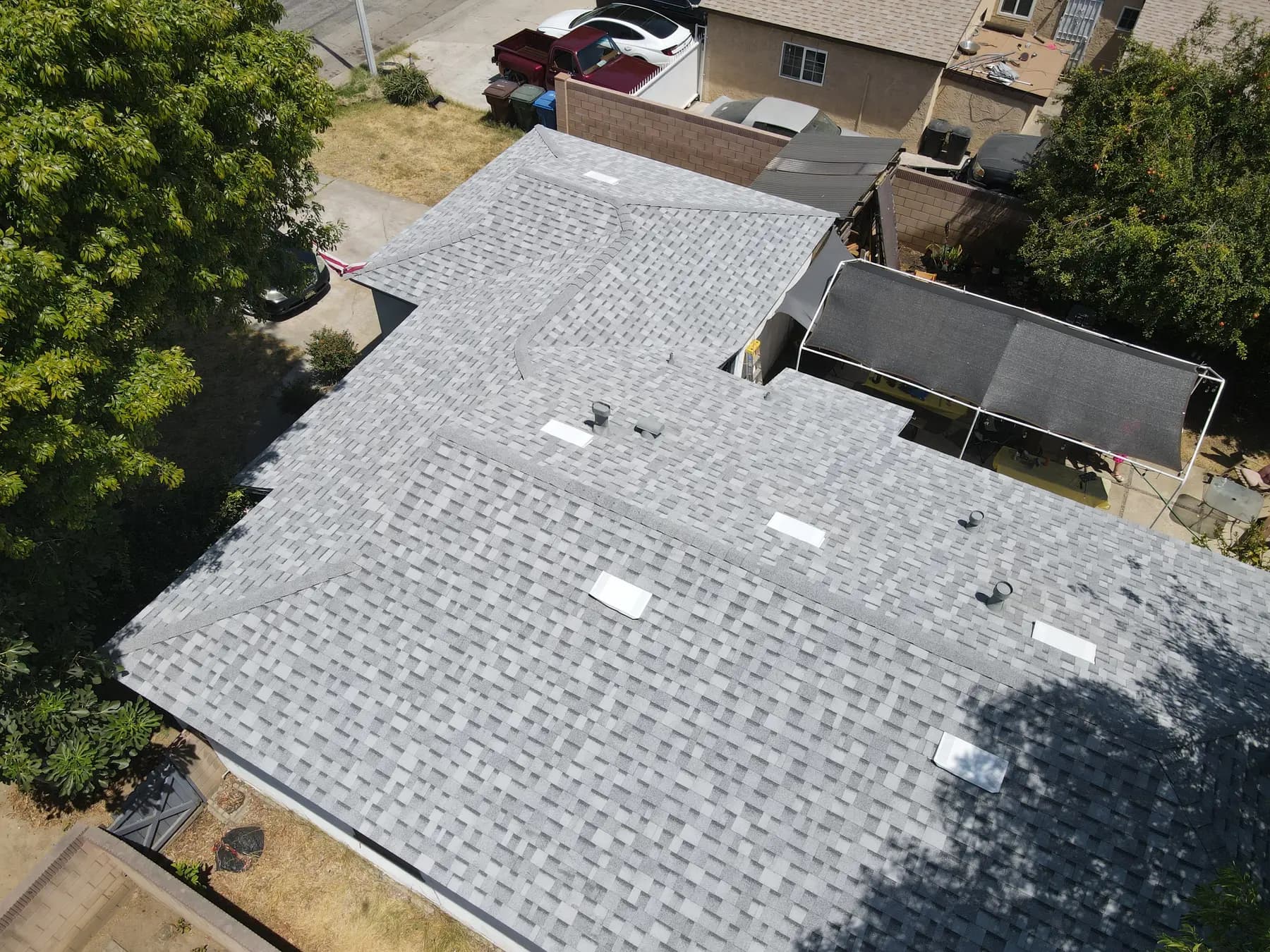 Aerial view of a large single-story home in Hacienda Heights with a new light gray shingle roof, white box vents and clean ridge caps