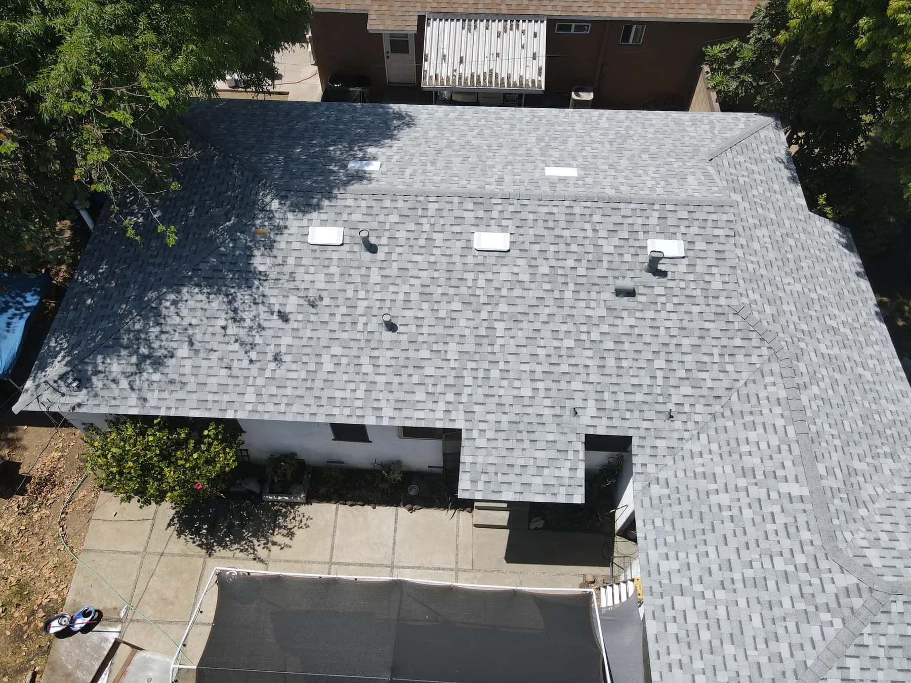 Overhead view of the front of the home, with its new shingles and its row of white box vents