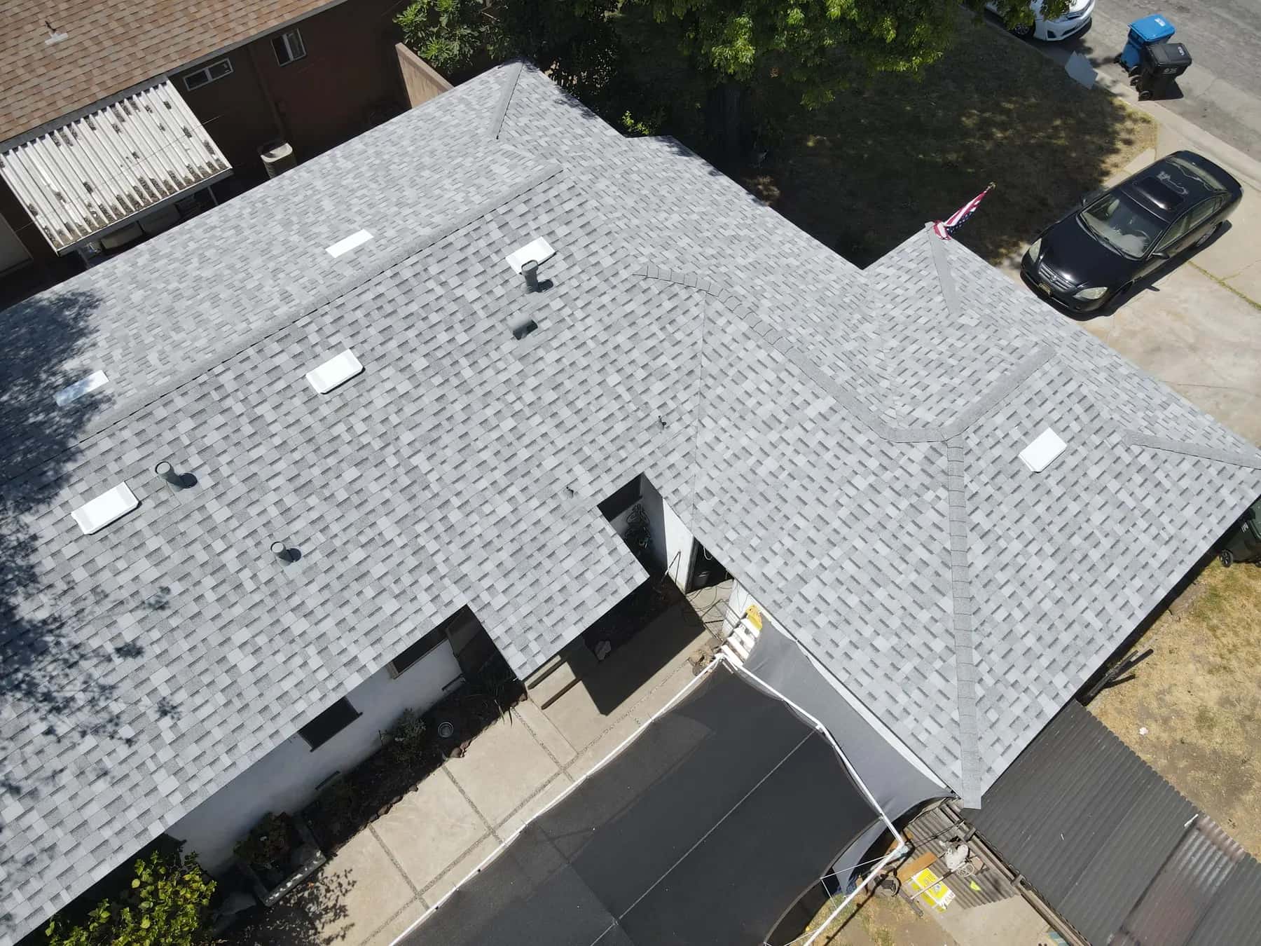 Angled view along the roof, with the ridge caps, valleys and box vents set into the new shingles