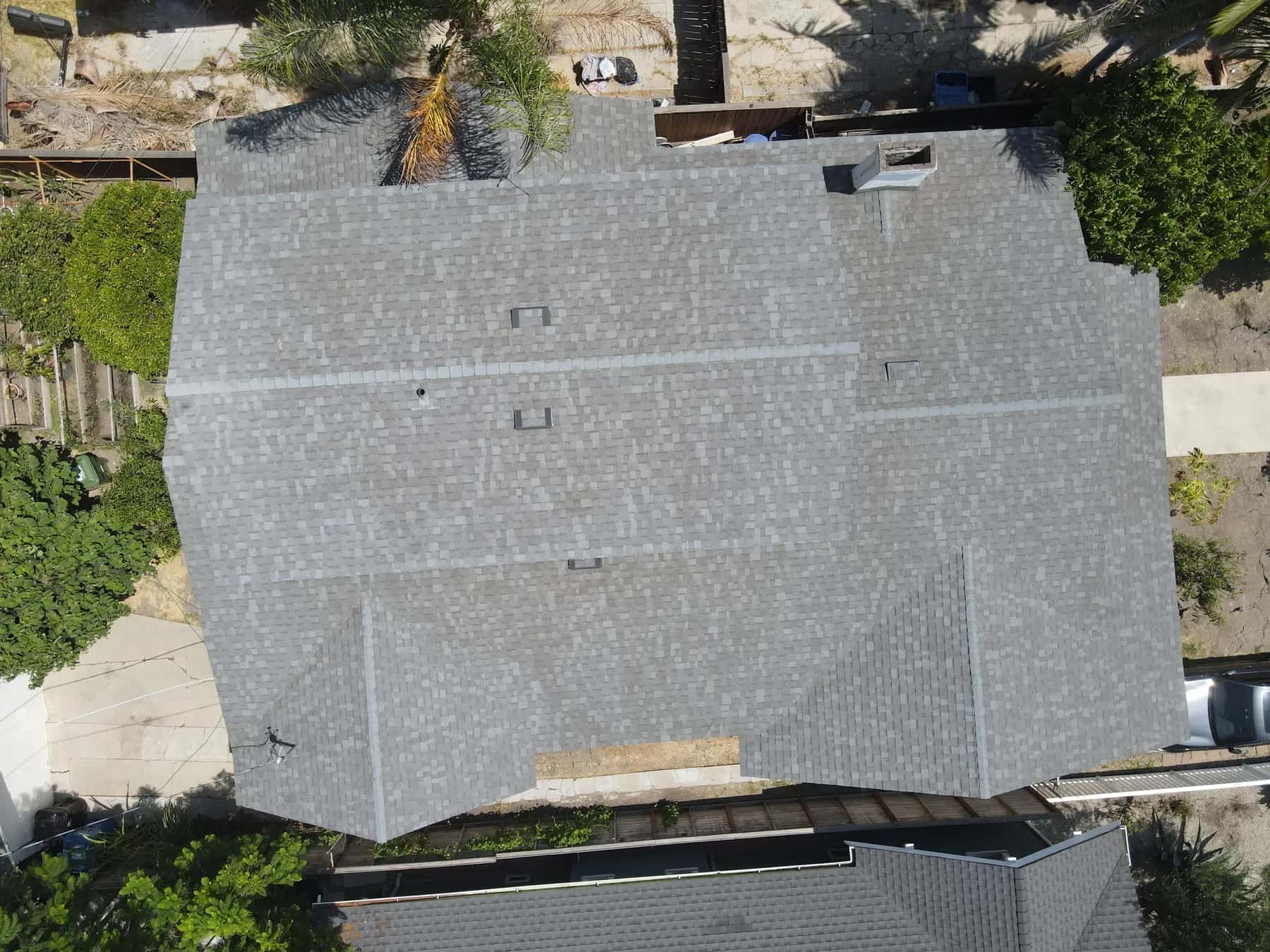 Straight-down view of the whole roof, with its box vents, chimney and clean ridge lines