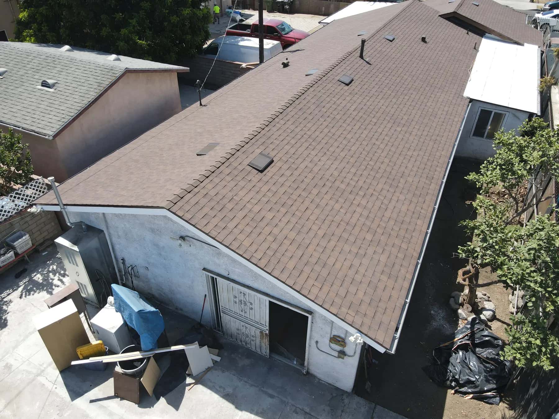 The rear building seen from the corner, with the new shingle roof running straight from ridge to eave