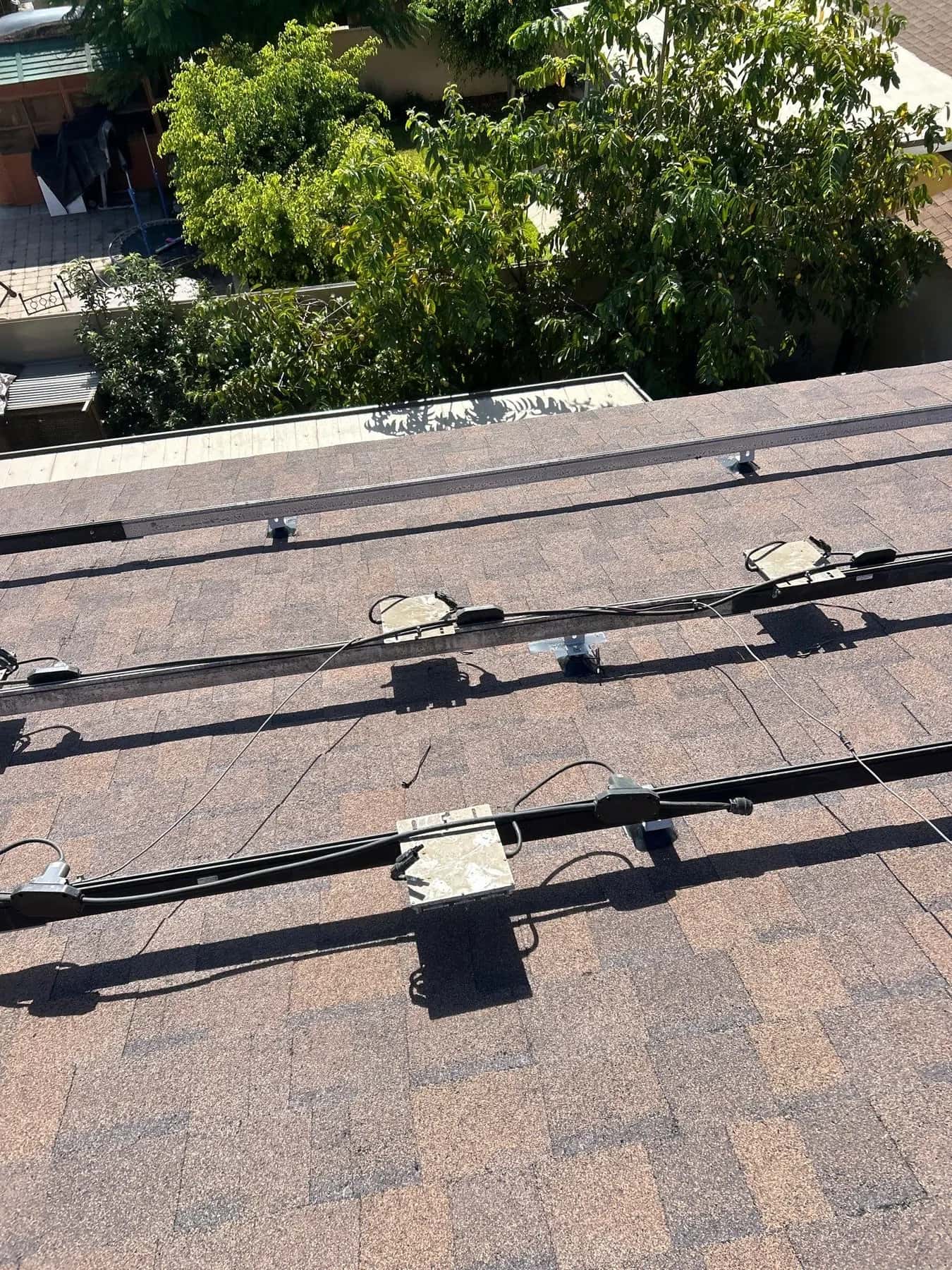 Rails running across the new shingles, each microinverter fixed in its place