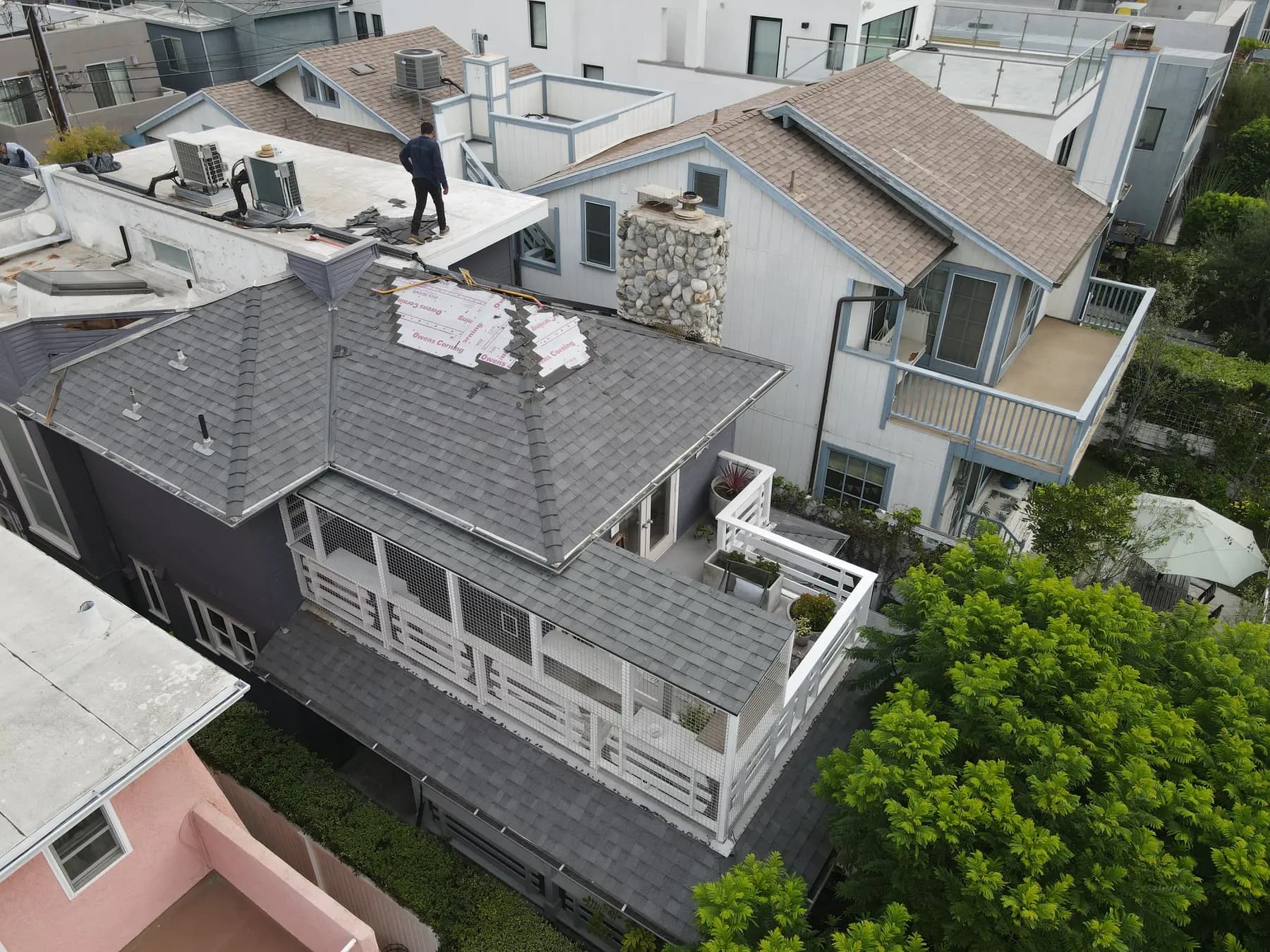 Aerial view of the home with the first sections stripped and covered in underlayment, beside the rear terrace